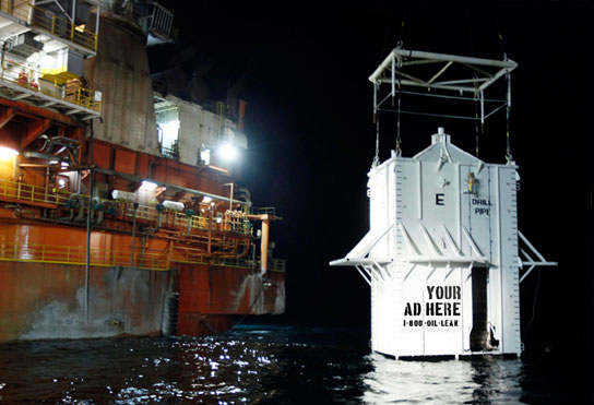 Giant container lowered into oil-fouled gulf